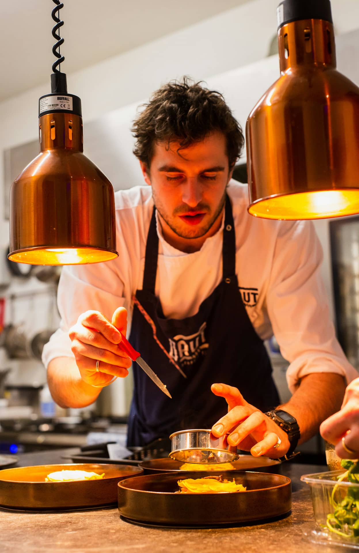 The chef finishing a plate at the pass